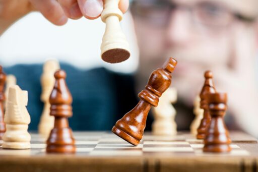 A photo showing chess player outthinking their opponent. This is an analogy of embracing a specific domain name within a larger digital market, symbolizing niche market precision.